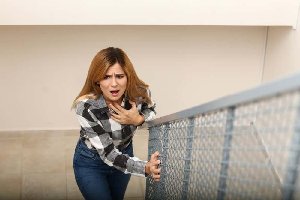 woman having panic attack while walking upstairs